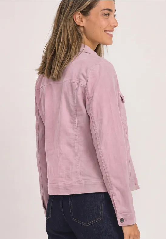 Femme de profil porte une veste en lin rose clair.