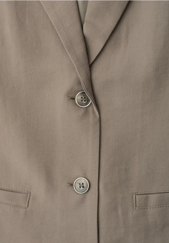 Nahaufnahme einer taupefarbenen Blazer-Jacke mit Reverskragen, zwei Knöpfen und Pattentaschen.