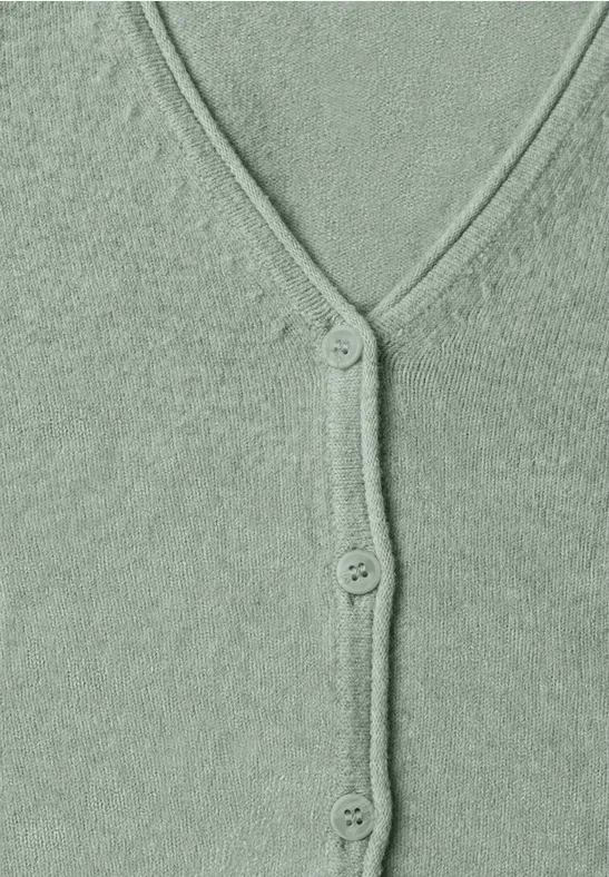 Nahe Aufnahme eines grünen Strickcardigans mit V-Ausschnitt und drei Knöpfen.