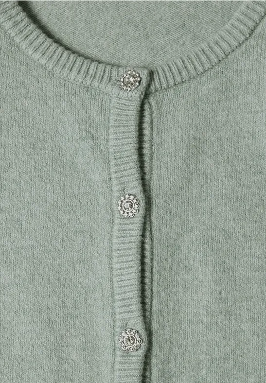 Nahtlos gestrickter hellgrüner Cardigan mit funkelnden silbernen Knöpfen.