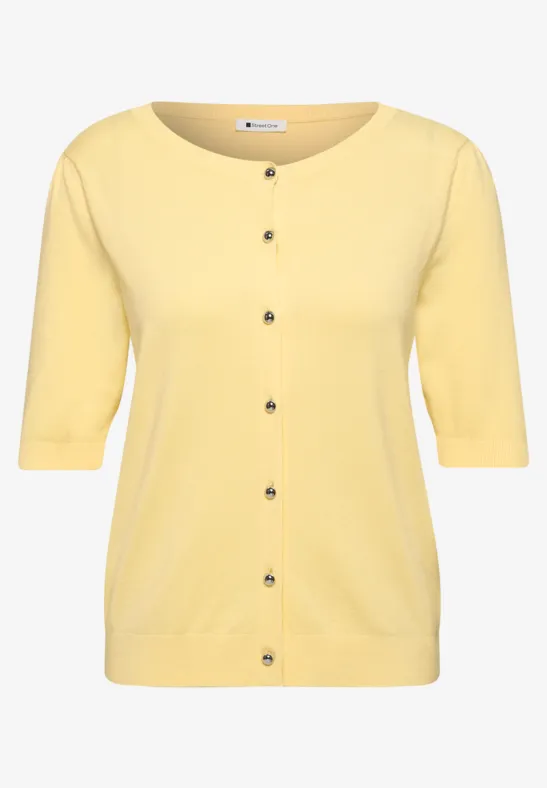 Cardigan femme jaune en tricot avec manches mi-longues et patte de boutonnage.