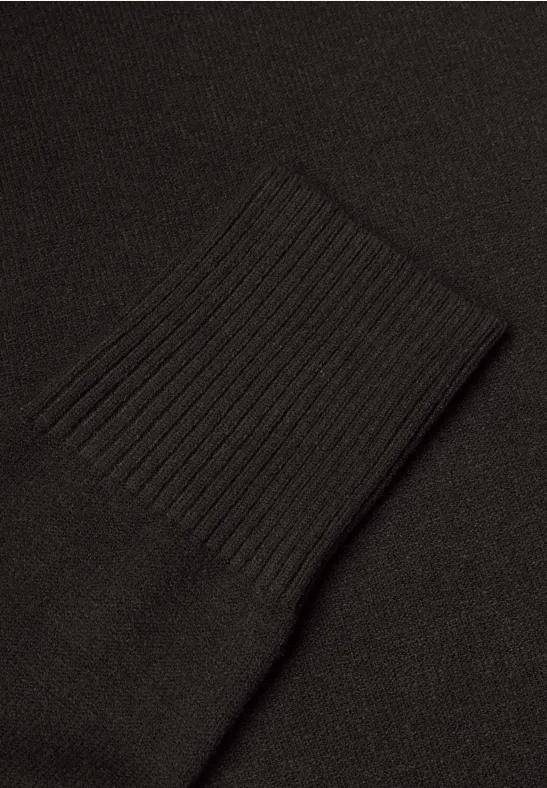 Nahaufnahme eines schwarzen Strickärmelbündchens.