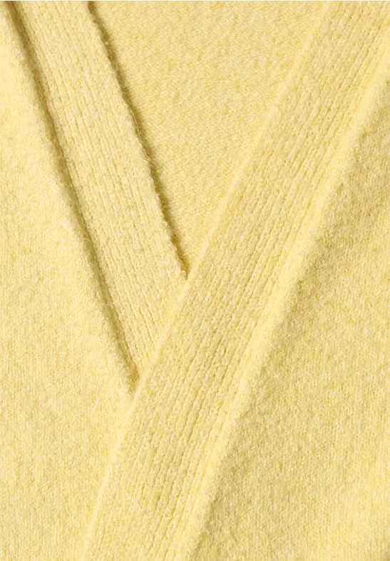 Nahaufnahme eines gelben Stoffes mit weicher, texturierter Oberfläche und Falten.