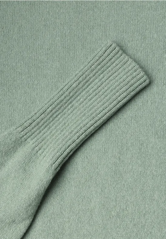 Nahaufnahme einer hellgrünen, gerippten Stricksocke aus weichem Stoff.