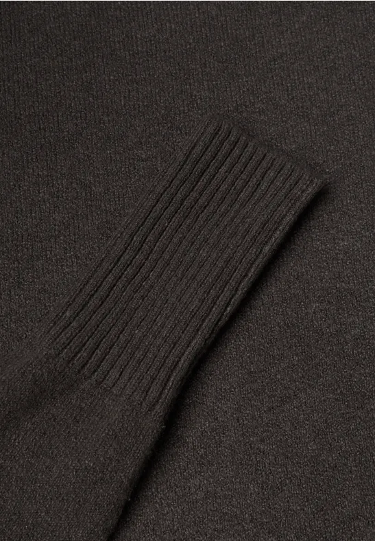 Un pull noir avec bord-côte au niveau de la manche.