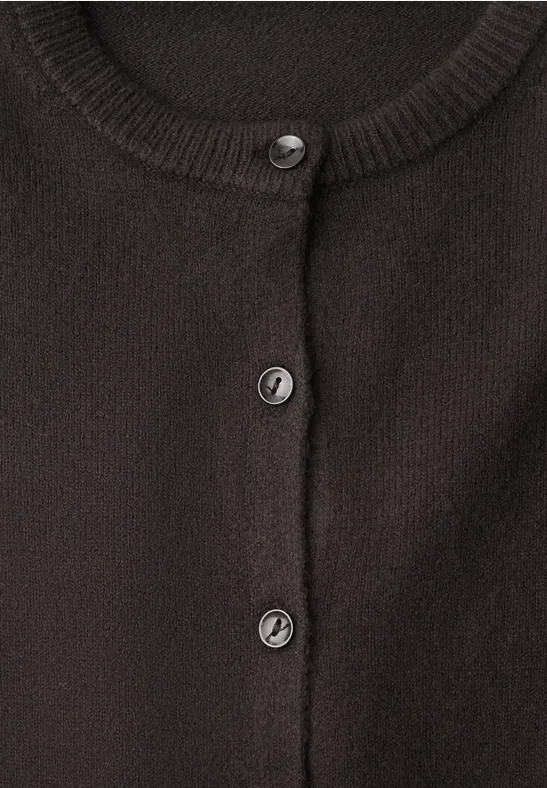Nahaufnahme eines schwarzen Strickcardigans mit runden Knöpfen und Rundhalsausschnitt.