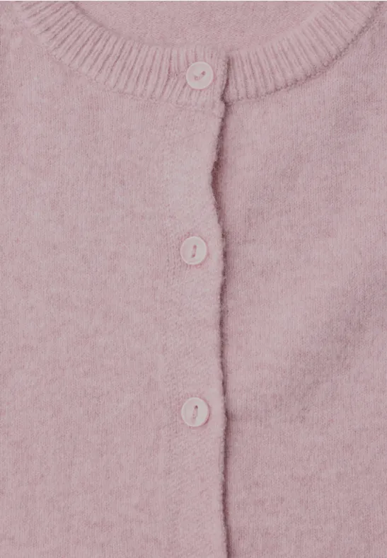 Nahaufnahme eines rosafarbenen Strickcardigans mit Knöpfen.