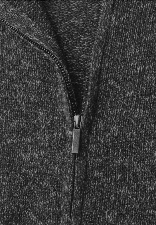 Nahaufnahme eines dunkelgrauen Strickstoffs mit Reißverschluss in der Mitte.
