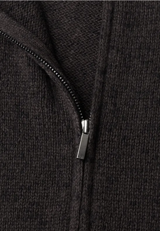 Nahaufnahme eines dunkelbraunen Strickstoffs mit sichtbarem Reißverschluss
