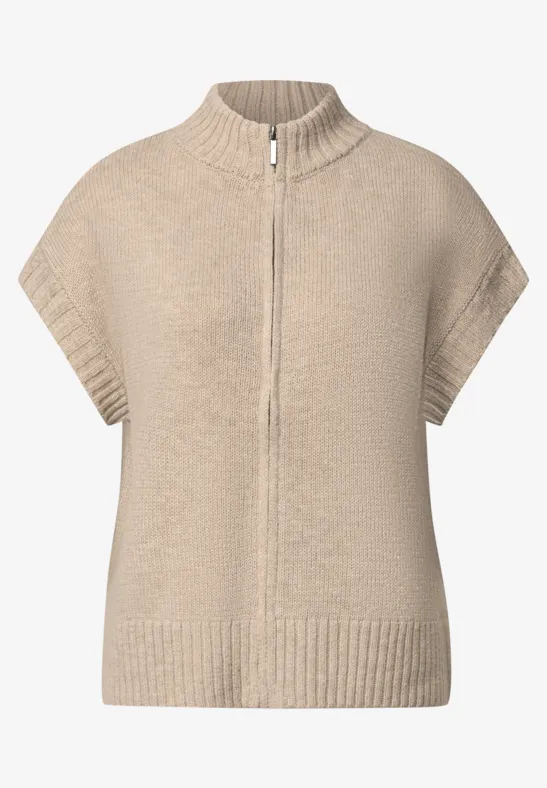 Beige gebreide cape met rits, opstaande kraag en korte mouwen.