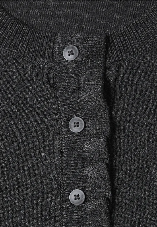 Nahaufnahme eines schwarzen Strickcardigans mit drei Knöpfen und geripptem Bund.
