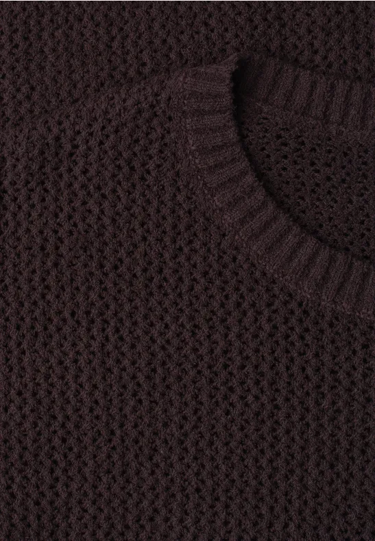 Gros plan sur un pull en maille épaisse marron foncé