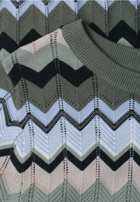 Gebreid stofpatroon met zigzagstrepen in groen-, grijs- en zwarte tinten.