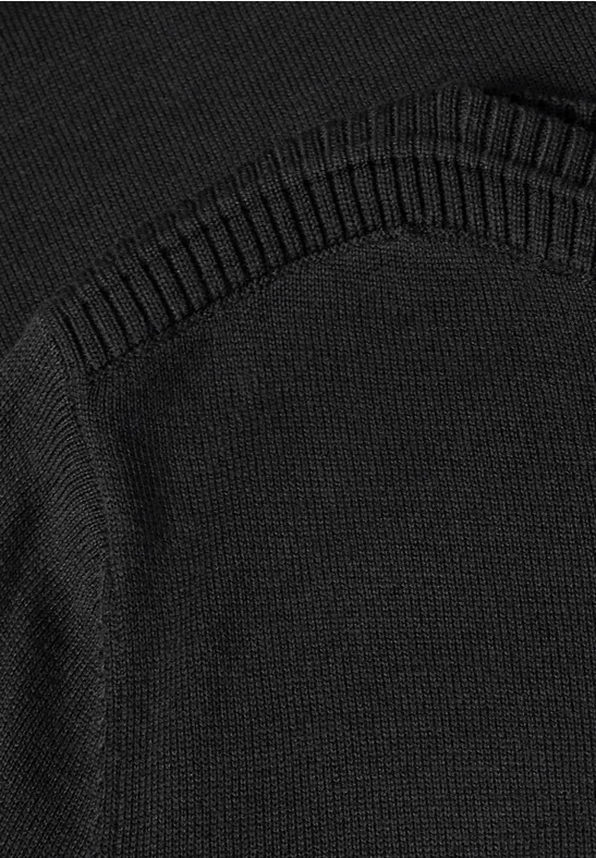 Schwarz gestricktes Kleidungsstück mit feinem Rippstrickmuster und sauberer Naht.