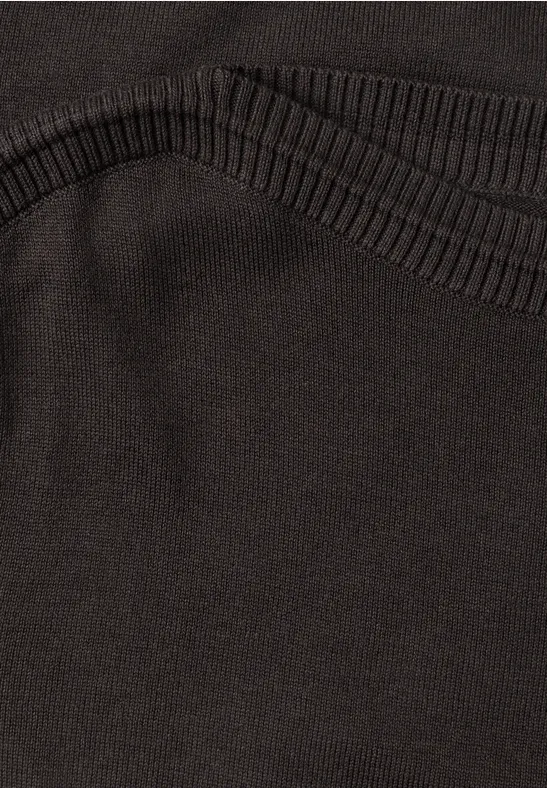 Nahaufnahme eines schwarzen Textilkleidungsstücks mit strukturierter Bundnaht.