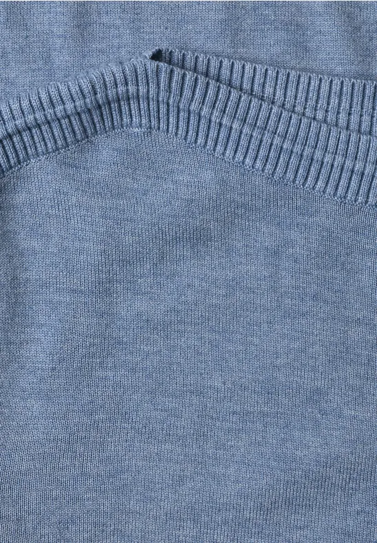 Nahaufnahme eines hellblauen Strickpullovers mit geripptem Saum.