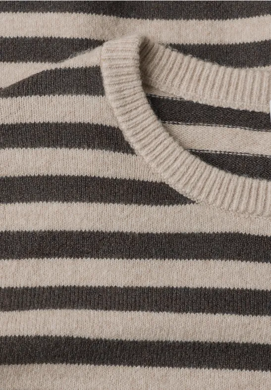Nahaufnahme eines gestrickten Pullovers mit beigen und braunen horizontalen Streifen.