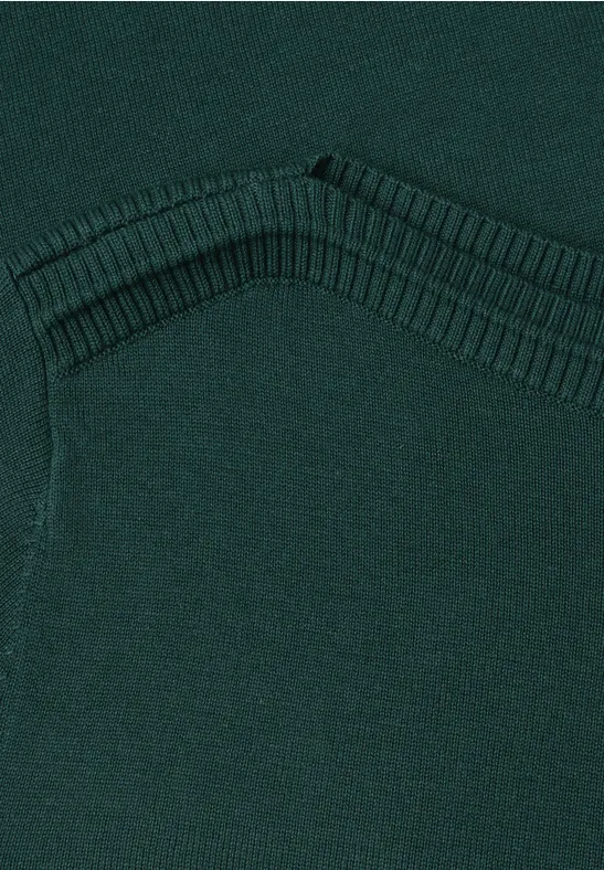 Nahaufnahme eines dunkelgrünen Strickpullovers mit V-förmiger Ziernaht.