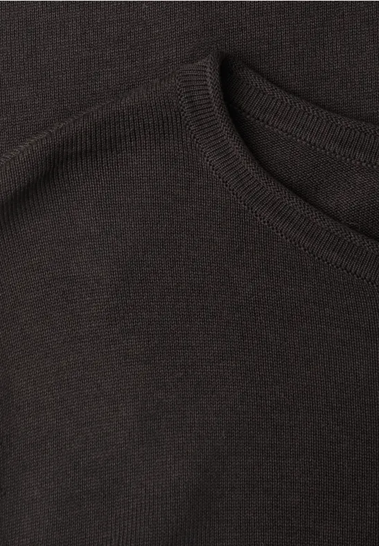 Nahaufnahme eines schwarzen Strickpullovers mit Rundhalsausschnitt.