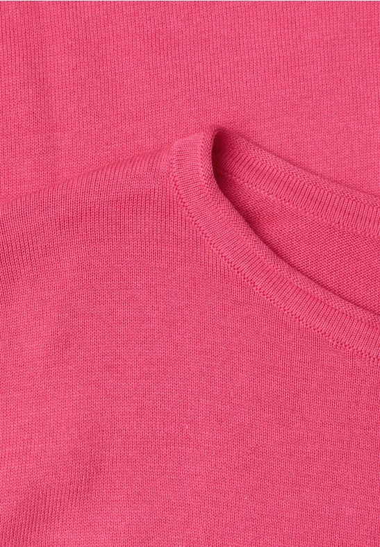 Nahaufnahme eines rosafarbenen T-Shirts mit sichtbarem Rundhalsausschnitt und feiner Stoffstruktur.