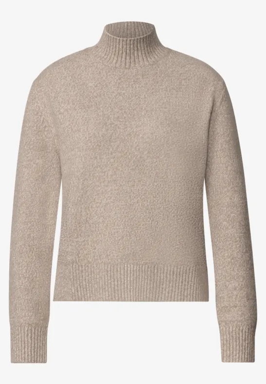 Pull à col roulé beige en maille douce avec manches longues.