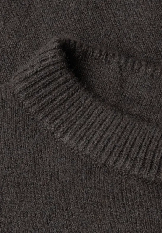 Gros plan sur un pull en maille marron avec col côtelé et texture douce.