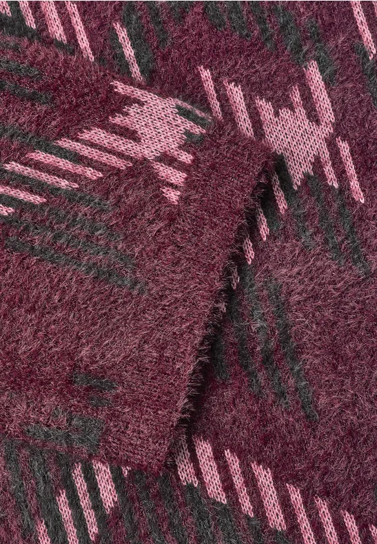 Nahaufnahme eines flauschigen, bordeauxroten Stoffes mit rosa-grünem Hahnentrittmuster.