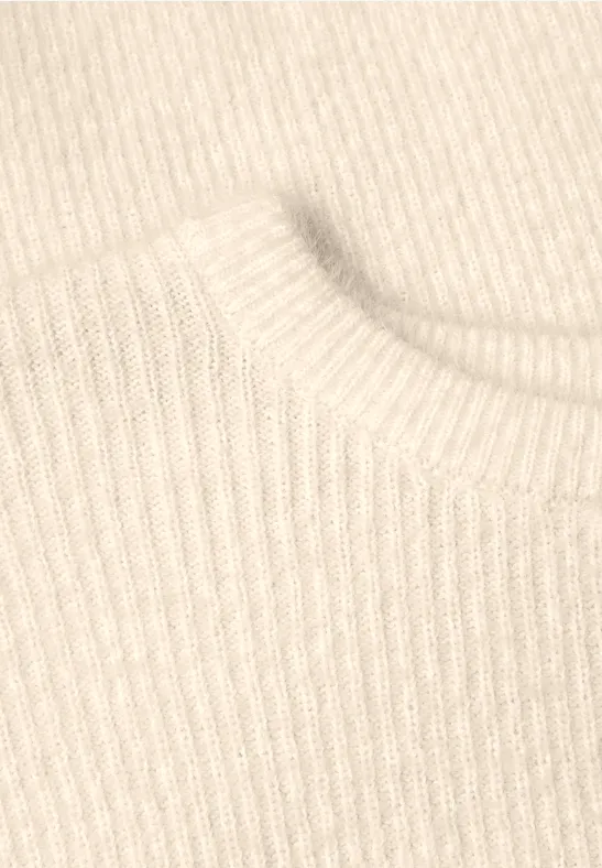 Nahaufnahme eines beigen, gerippten Strickstoffs, vermutlich ein Pulloverkragen.