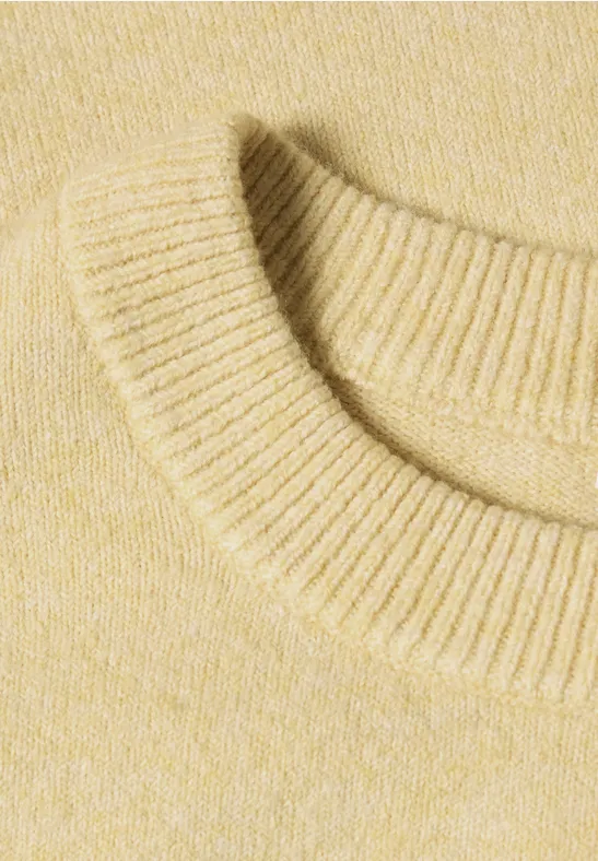 Nahaufnahme eines cremefarbenen Strickpullover-Ausschnitts mit Rundhals
