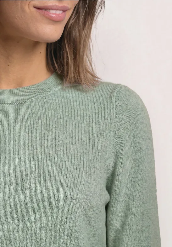 Oberkörper einer Frau in einem hellgrünen Pullover mit Rundhalsausschnitt