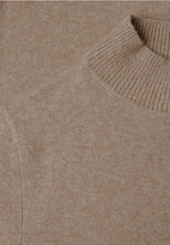 Nahaufnahme eines beigen Strickpullovers mit Rollkragen und feiner Maserung