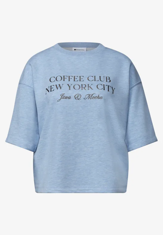 Jasnoniebieski t-shirt z napisem 'COFFEE CLUB NEW YORK CITY Jean & Mote' na przodzie.