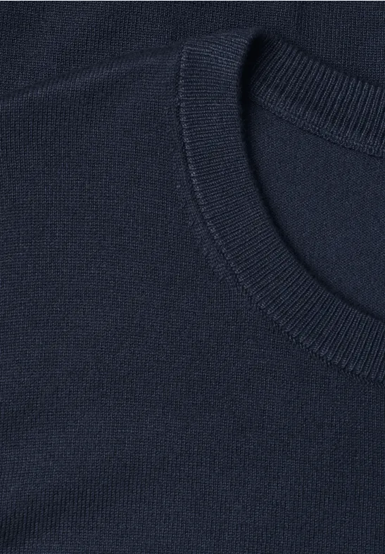 Nahaufnahme eines marineblauen Rundhalsausschnitts aus feinem Strickstoff.