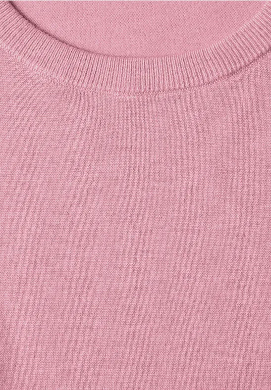 Close-up van de halslijn van een roze trui van gebreide stof