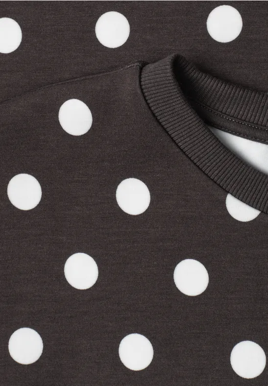 Schwarzes Shirt mit weißen Punkten und Rundhalsausschnitt.