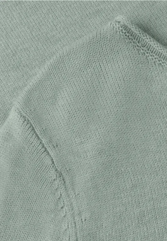 Naheinstellung eines hellgrünen gestrickten Kleidungsstücks mit Naht