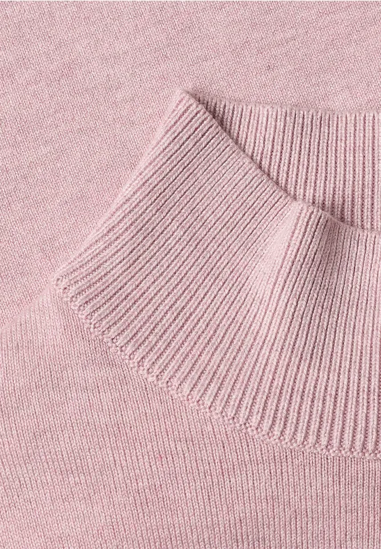Różowy sweter z dzianiny z prążkowanym, podwyższonym kołnierzem.