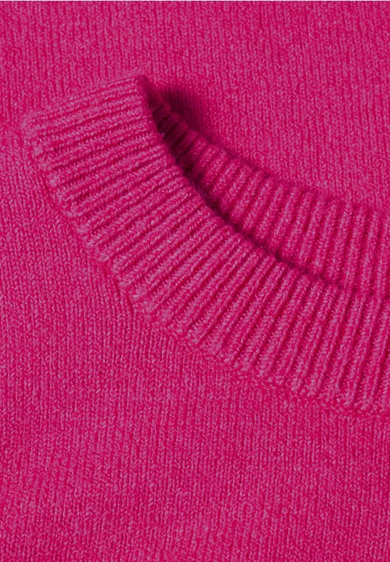 Gros plan d'un pull tricoté rose vif avec un col ras du cou côtelé
