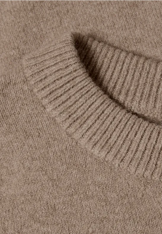 Detailaufnahme eines braunen Strickpullovers mit Rundhalsausschnitt.