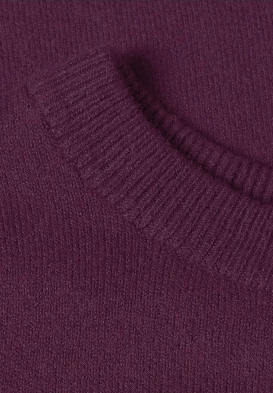 Nahaufnahme eines violetten Strickpullovers mit Rundhalsausschnitt.
