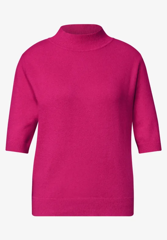 Ein fuchsiafarbener Pullover mit hohem Kragen und halblangen Ärmeln.