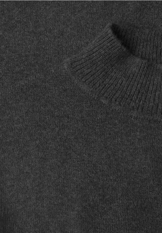 Nahaufnahme eines schwarzen Rollkragenpullovers aus Strickmaterial.