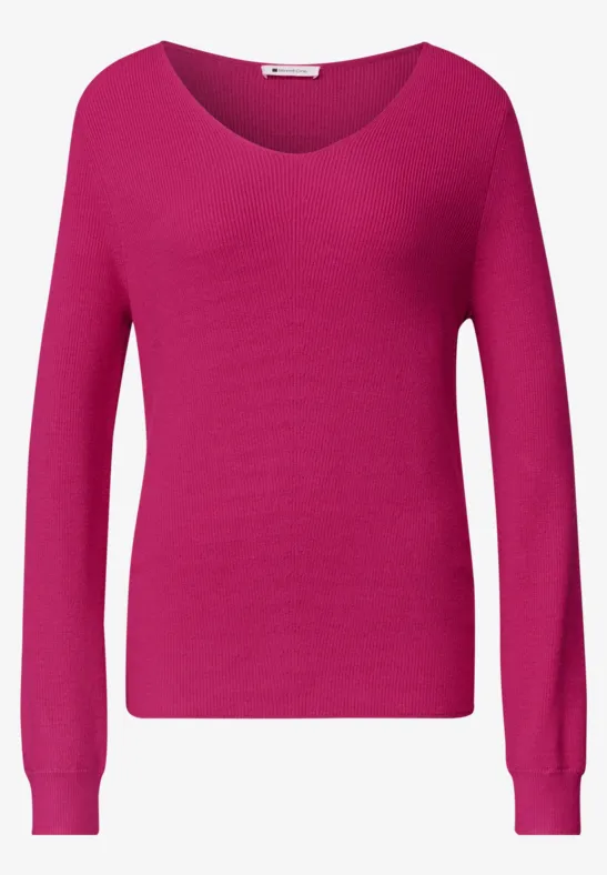 Ein schlichter, langärmliger Damenpullover in knalligem Pink
