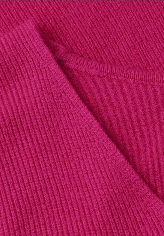Close-up eines pinken Rippstrick-Stoffes mit V-Ausschnitt.