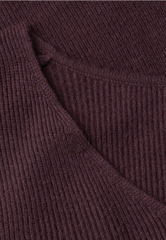 Gros plan sur un vêtement en maille côtelée violet foncé avec encolure en V.