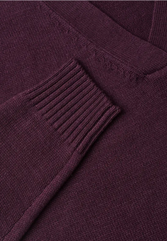 Nahaufnahme eines dunkelroten Strickpullovers mit V-Ausschnitt.