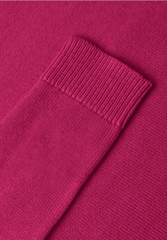 Nahaufnahme eines pinken Strickpullovers auf passendem Hintergrund
