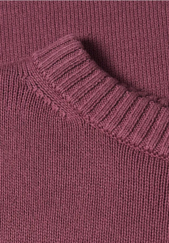 Nahaufnahme eines burgunderfarbenen Strickpullover-Kragens.