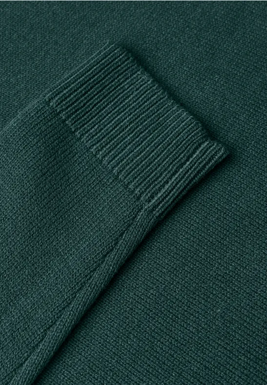 Nahaufnahme eines dunkelgrünen Strickpullovers mit Bündchen