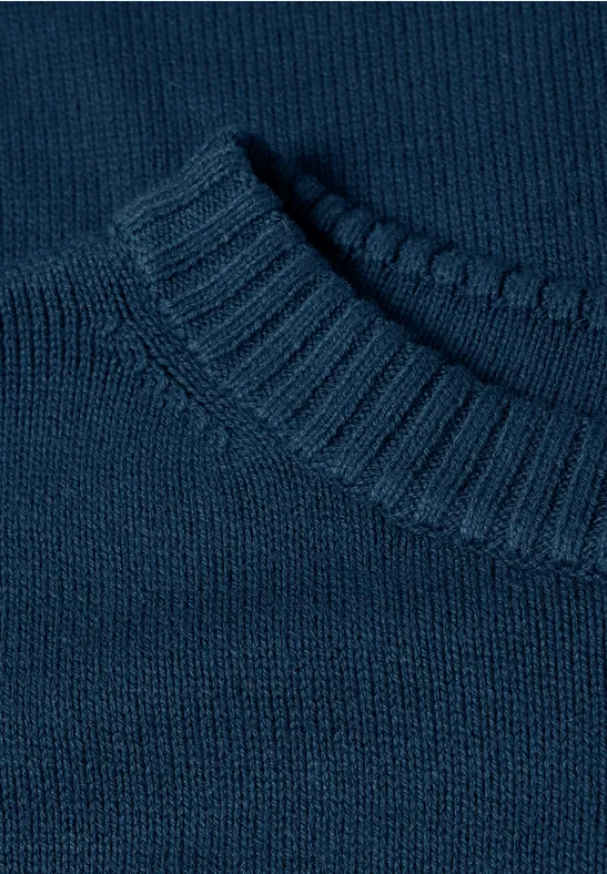 Nahaufnahme eines dunkelblauen, glatt gestrickten Pullovers mit Rundhalsausschnitt.